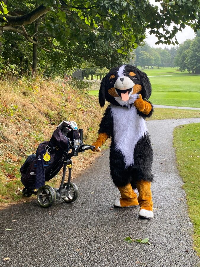 An image of our Mascot Muttley with a golf bag